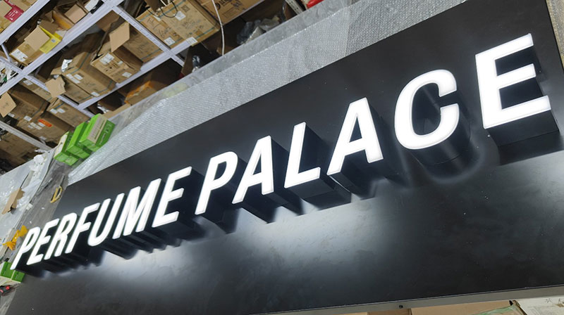 Face-lit trimless channel letters on a perfume retail storefront at night